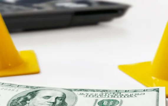 Safety cones surrounding a stack of money
