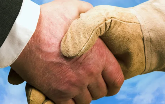 Executive and frontline worker shaking hands