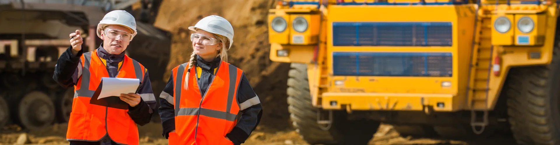 Two Workers in Hard Hats Walking Construction Site
