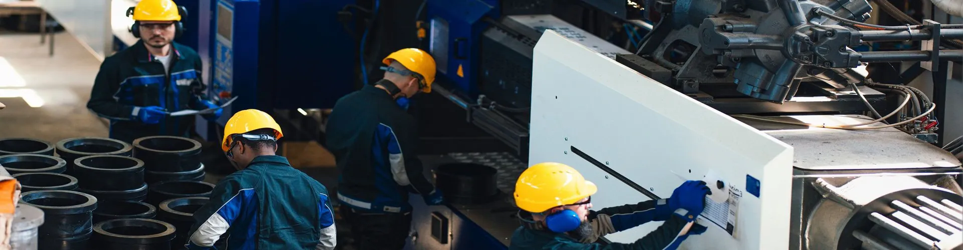 A group of workers in safety gear is seen operating and overseeing heavy machinery