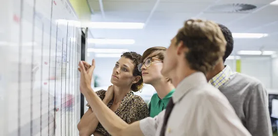 Team looking at work whiteboard